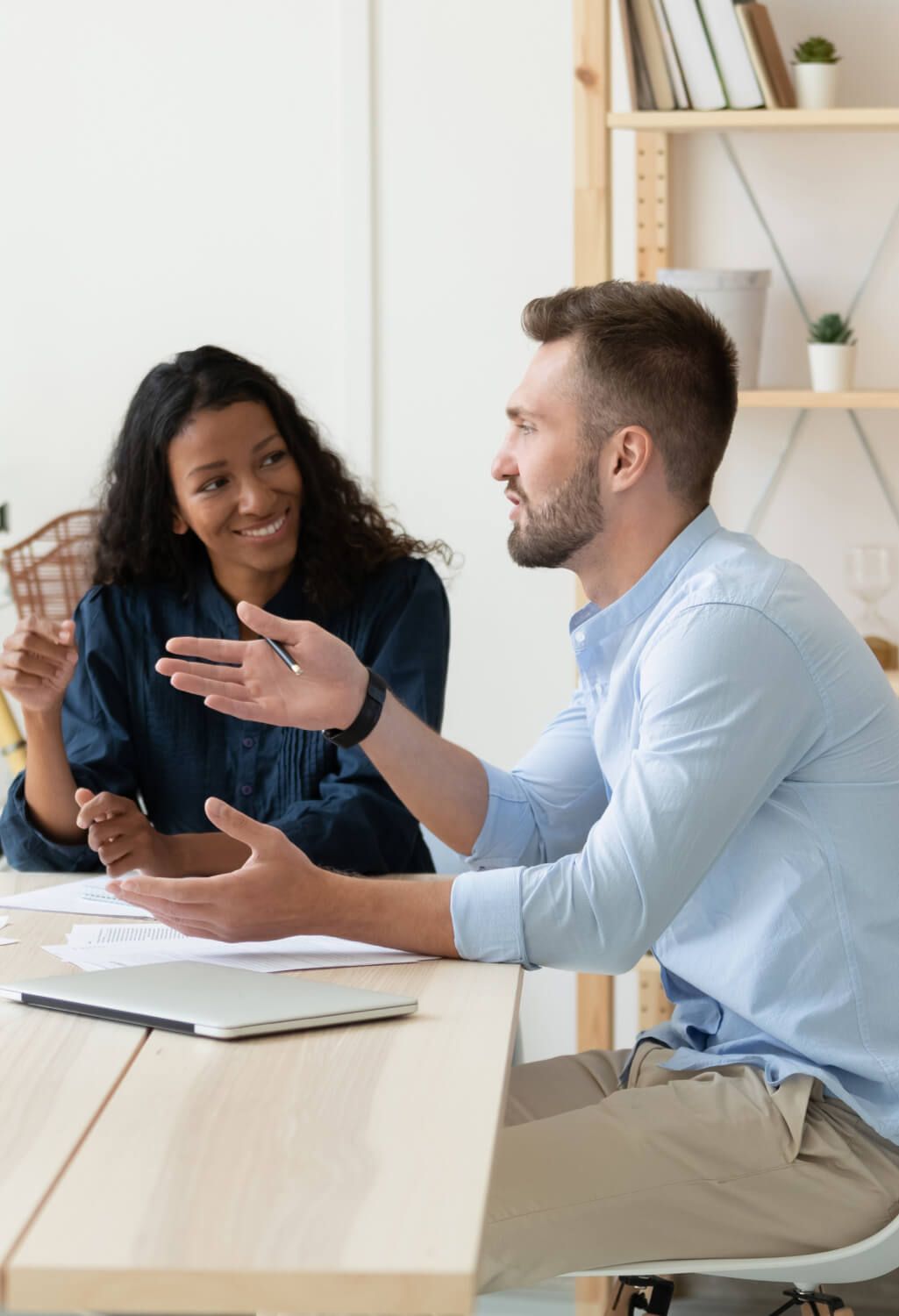 Man and woman conversing at a work desk