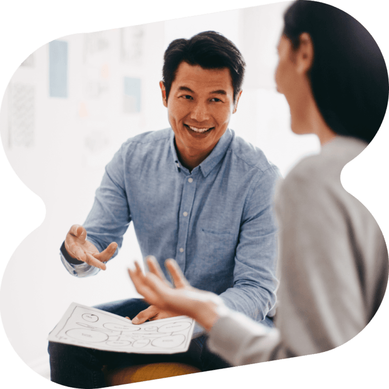 A man talking to a woman and holding a piece of paper