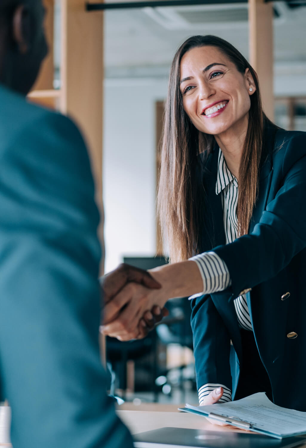 Woman shaking hands with a client at work