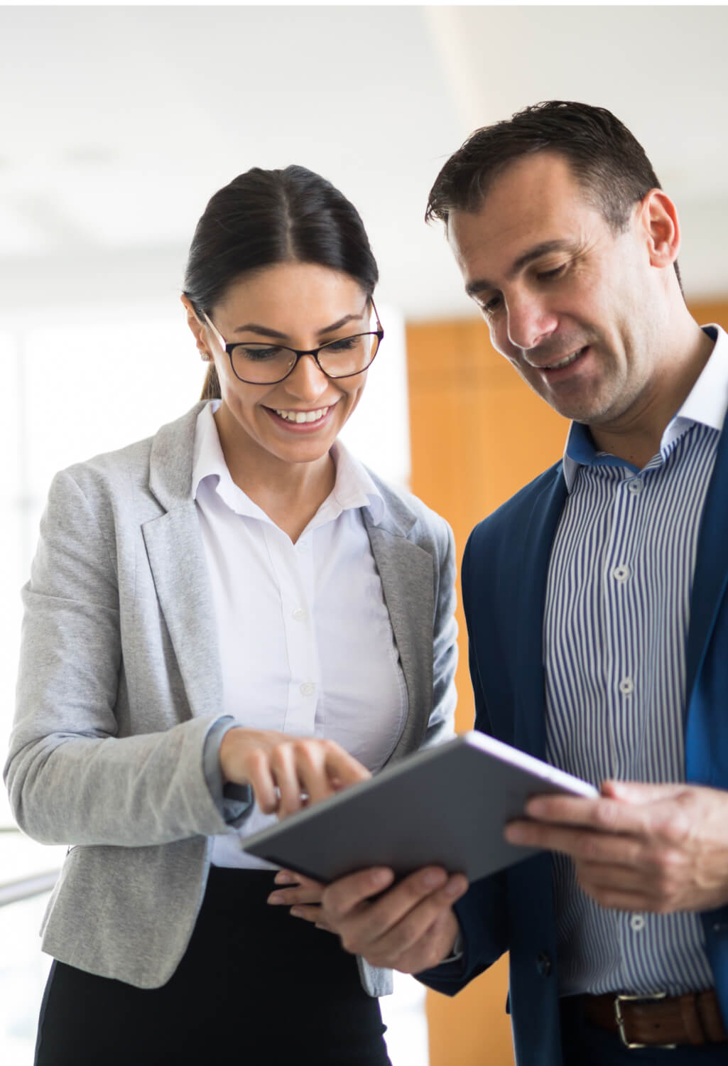 Man and woman looking down at tablet together