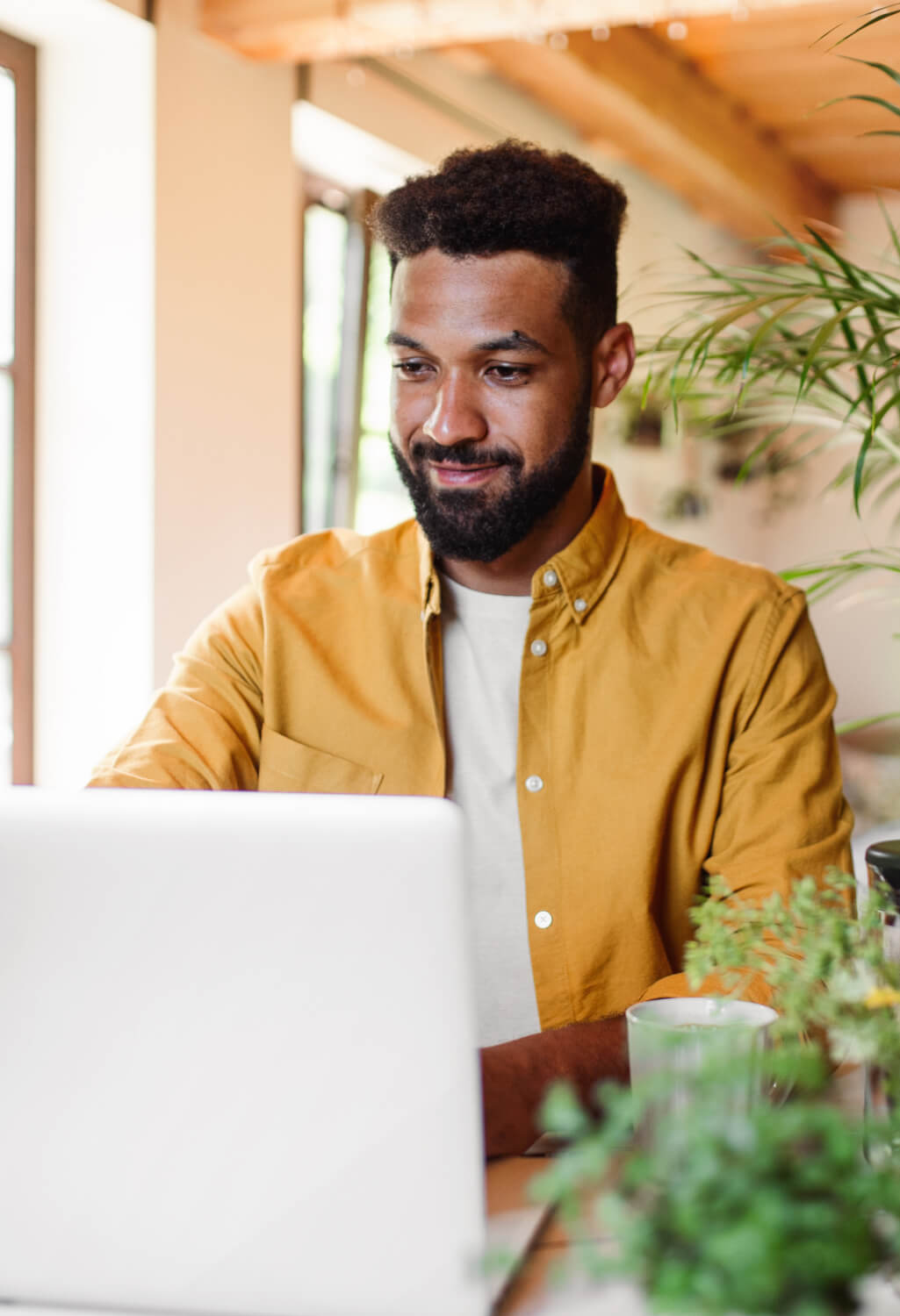 Man sitting at a table surrounded by plants