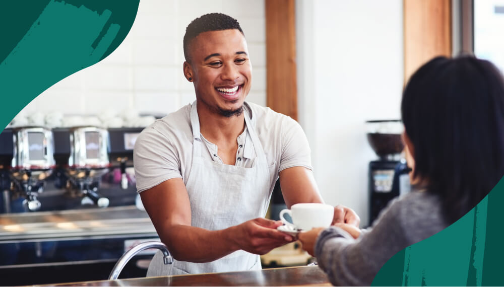 Barista handing cup of coffee to a customer