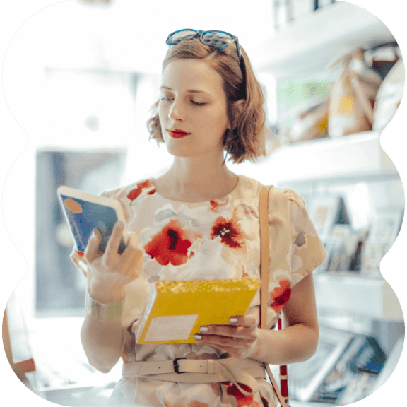 Woman standing in a store, holding different products