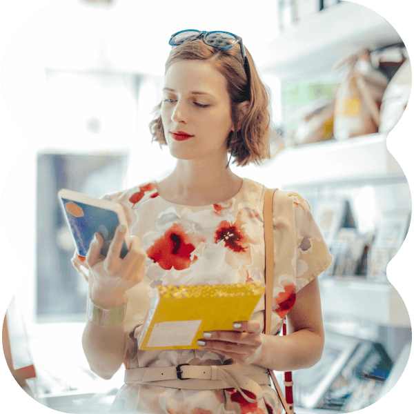 Woman standing in a store, holding different products and reading the packaging