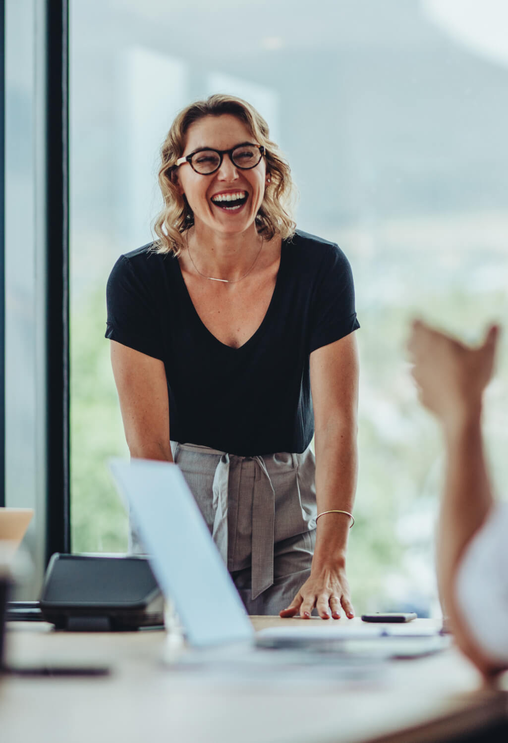 Woman standing at the end of an office conference table