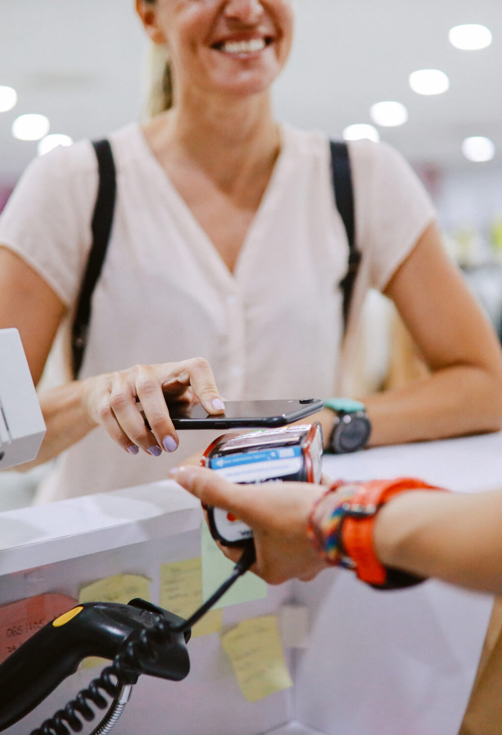 Woman using her smart phone to pay at a store