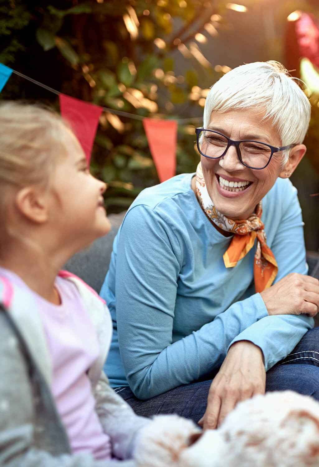 Woman and young girl laughing, sitting together