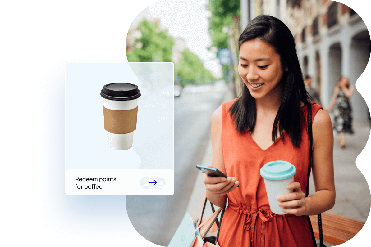 Woman smiling, walking down a street with coffee