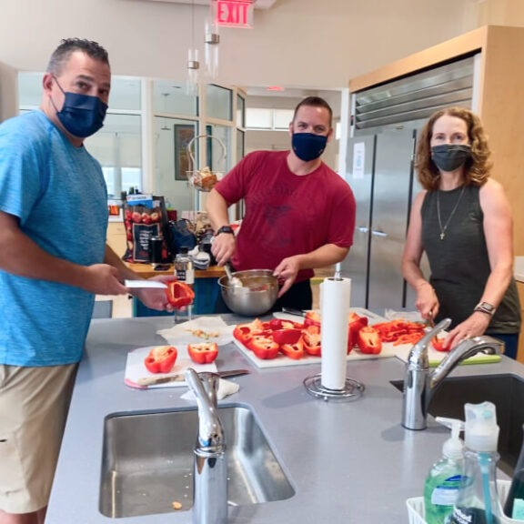 three people cooking in the kitchen