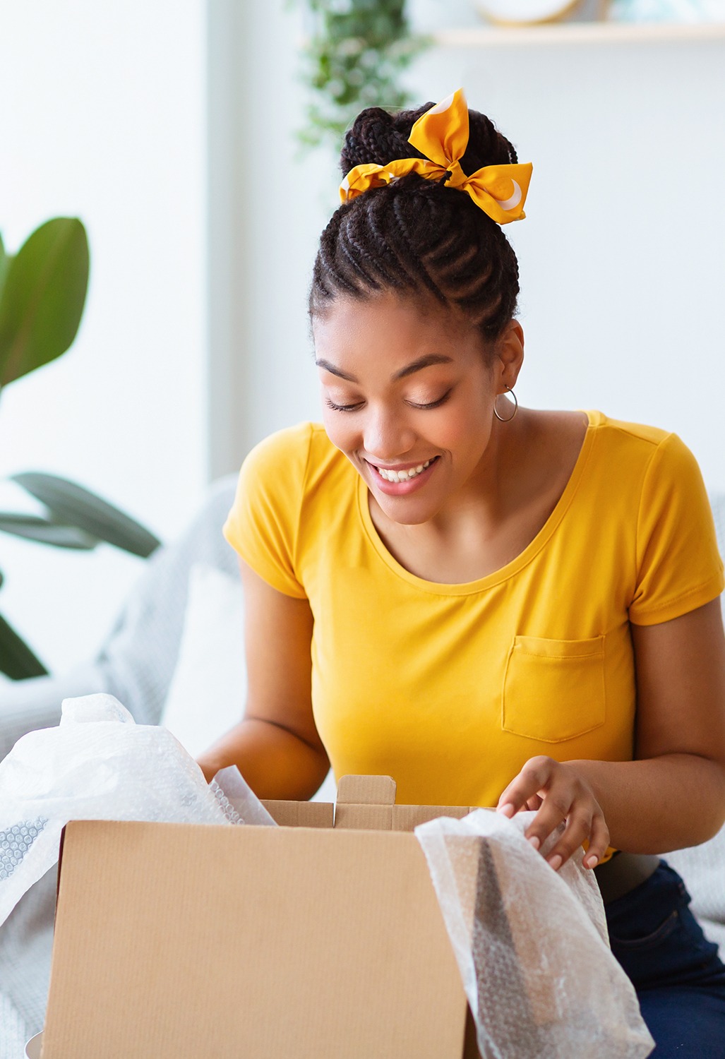 Excited young woman opens a subscription box.